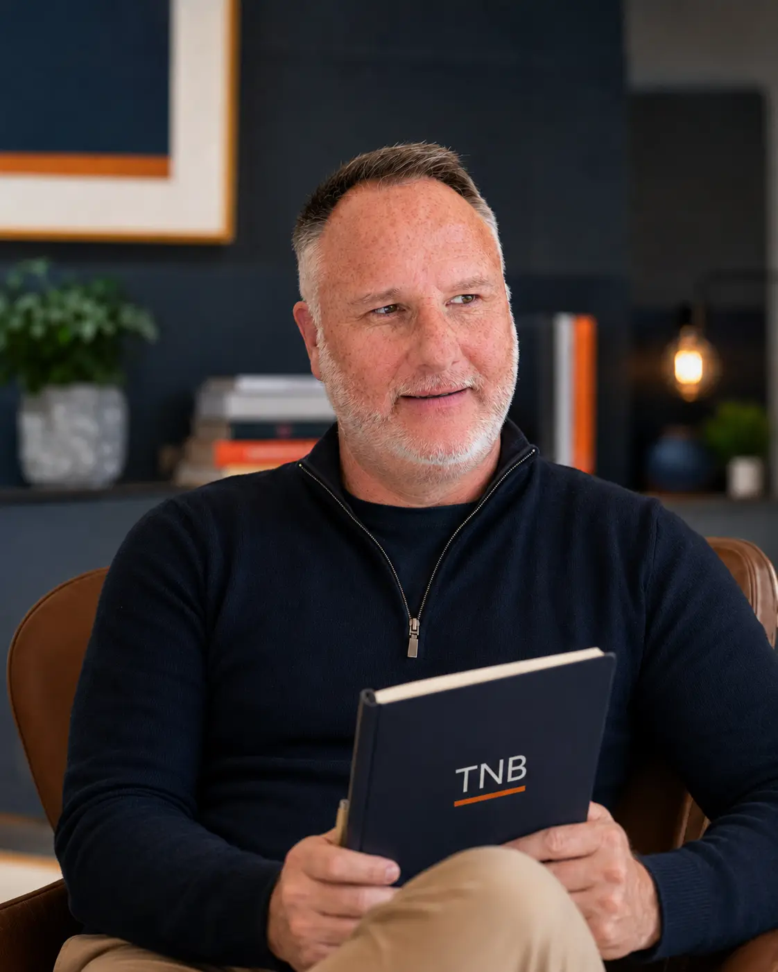 Dominic Scotton, founder of The Nursery Business, holding a TNB notebook